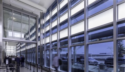 Vue de l'intérieur d'un bâtiment en verre avec des gens qui marchent