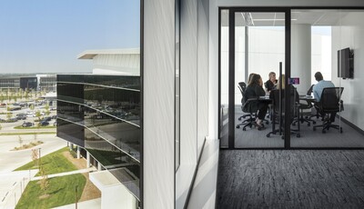 Façade extérieure d'un bâtiment avec des fenêtres intelligentes de gauche à droite sur un grand bâtiment moderne en verre et espace de bureau intérieur avec des travailleurs collaborant.