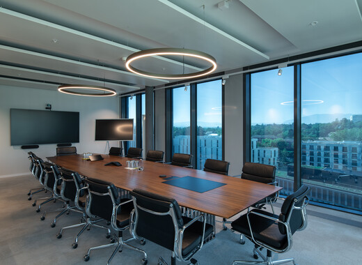 Intérieur du bâtiment, un bureau au milieu de l'espace. Arrière-plan : SageGlass teinté.