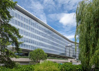 Façade d'un bâtiment avec du vitrage intelligent de gauche à droite sur un grand bâtiment moderne entièrement vitré.