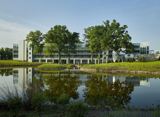 Extérieur d'un bâtiment architectural avec du vitrage intelligent donnant sur l'eau.