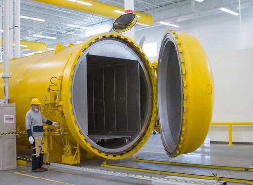 Intérieur d'une usine de fabrication avec un ouvrier pilotant une machine dans une centrale électrique en verre intelligente.