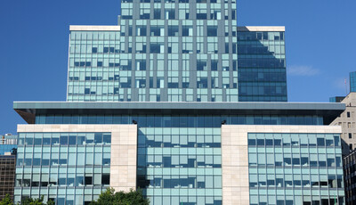 Façade de bâtiment avec de nombreux stores baissés en raison de l'éblouissement.