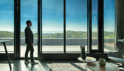 SageGlass Harmony installé dans un environnement de bureau, un homme pose devant les fenêtres.
