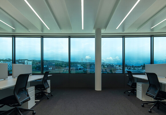 Espace de bureau commun avec du vitrage intelligent donnant sur la ville. 