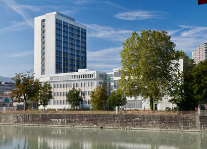 Façade de la tour PAV Pointe Nord. Le ciel est bleu, le nouveau bâtiment gris équipé de fenêtres intelligentes SageGlass se trouve à gauche de l'image. Un arbre se trouve à droite de l'image.