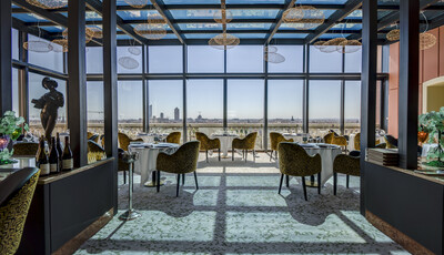 Intérieur d'un restaurant avec un espace de restauration unique et des fenêtres en verre intelligentes et personnalisées donnant sur la ville.